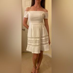 Off the shoulder white dress, above the knee with box pleats.